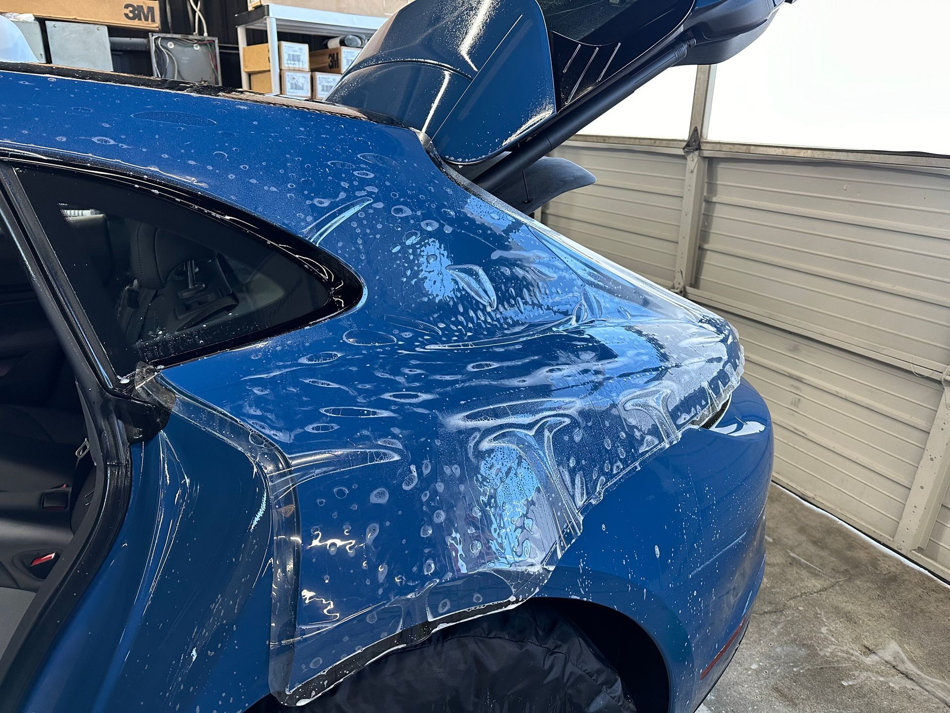 The back of a blue car with the trunk open