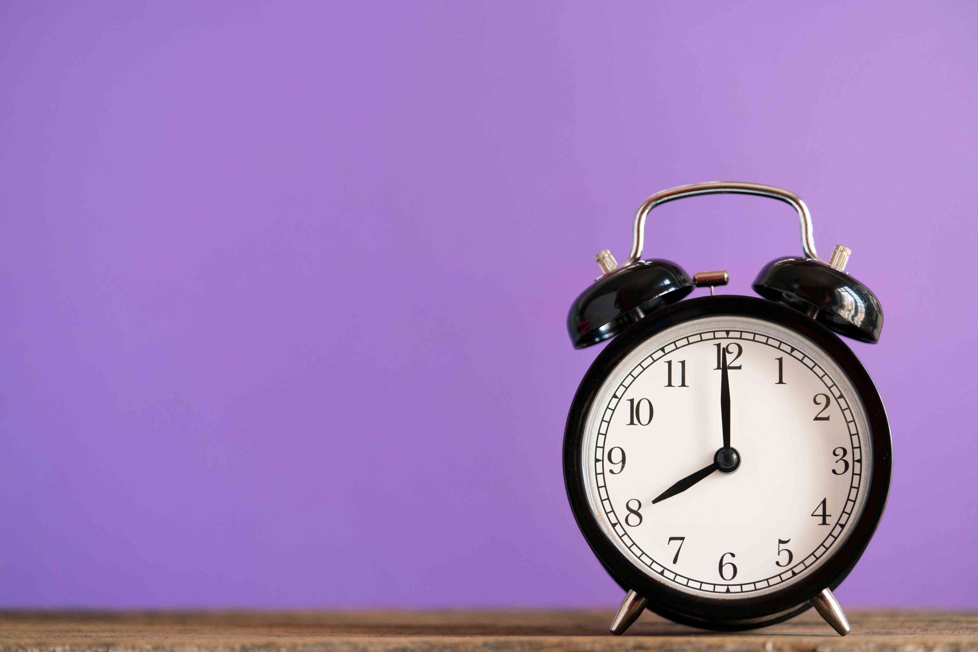 A clock in front of a purple background