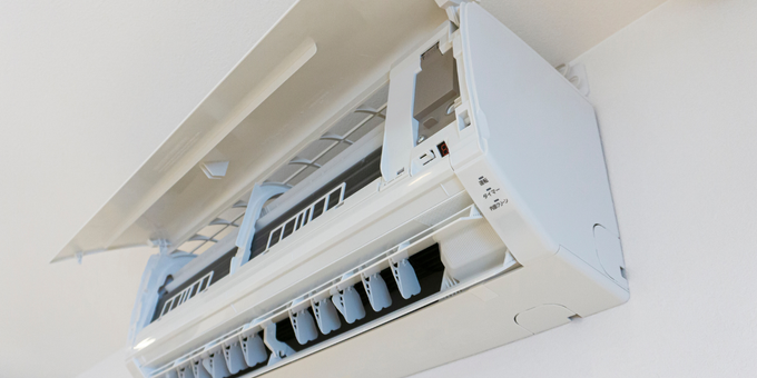 A white air conditioner is hanging from the ceiling in a room.