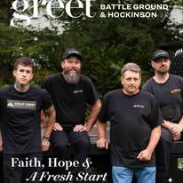 Four people in matching shirts stand outdoors in front of a truck, featured in a magazine titled 