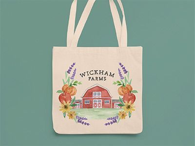 A tote bag with a barn and flowers on it.