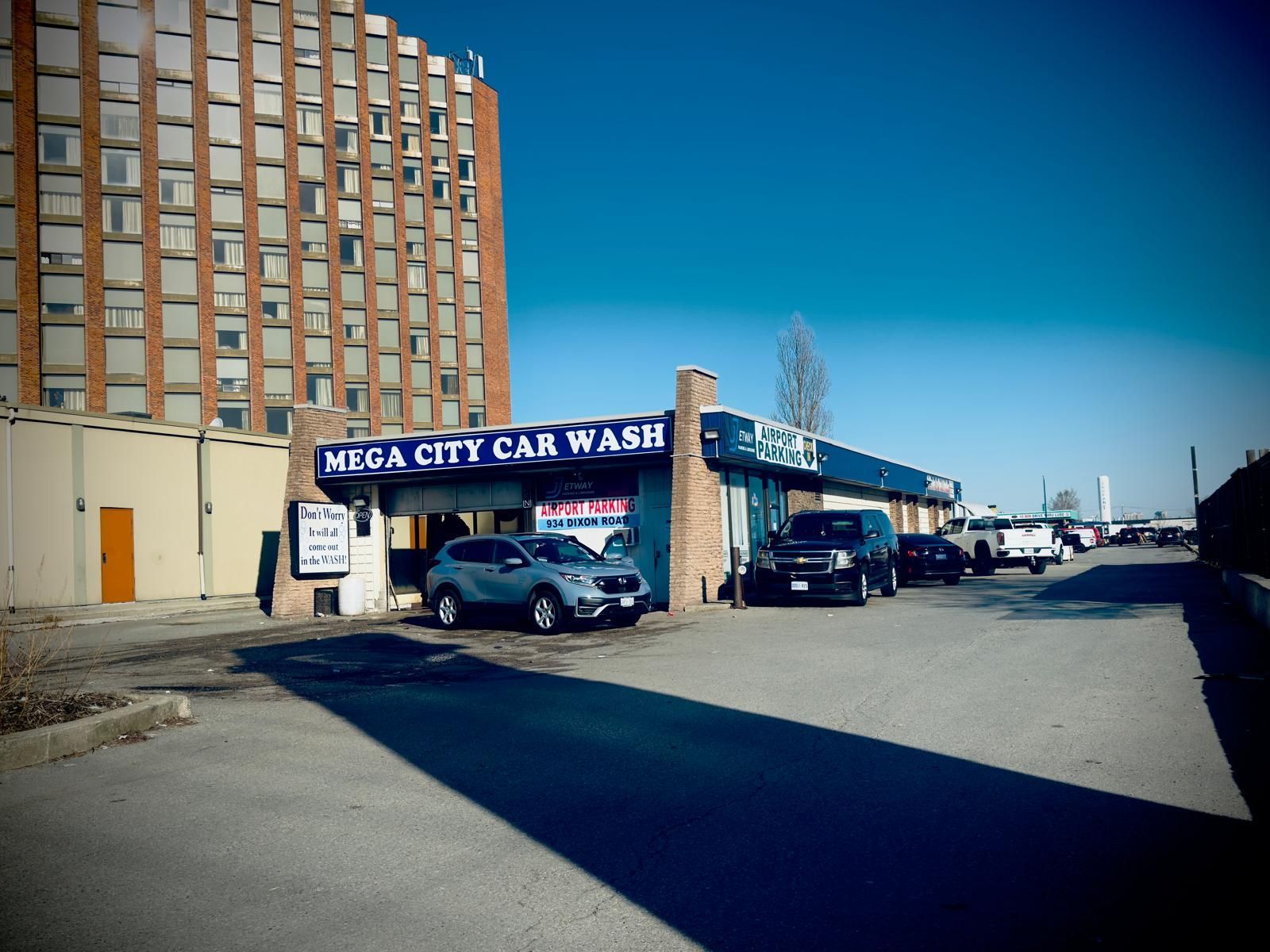 Cars are parked in front of a mega city car wash