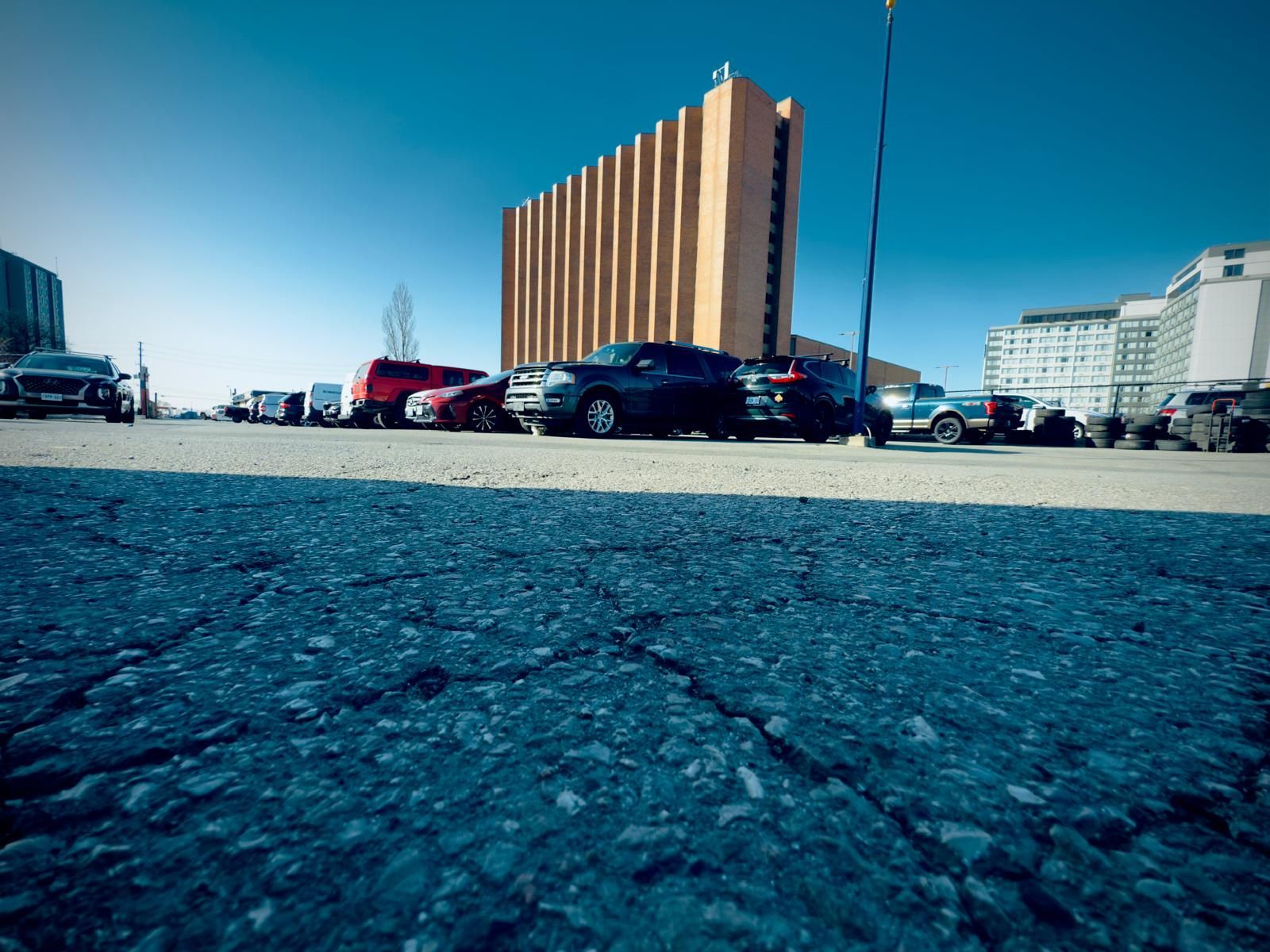A parking lot with cars parked in front of a building.