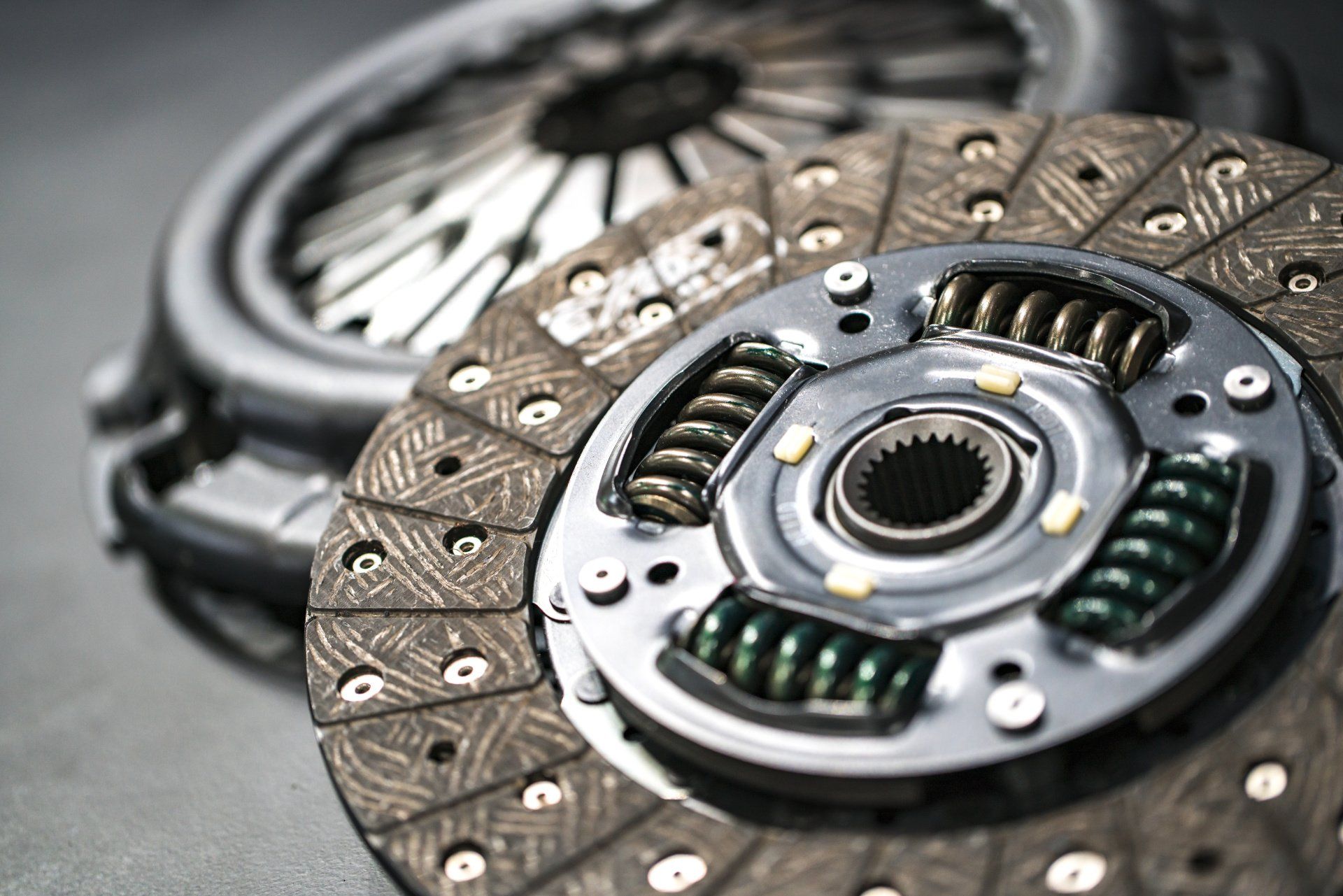 A close up of a clutch disc and clutch cover on a table.