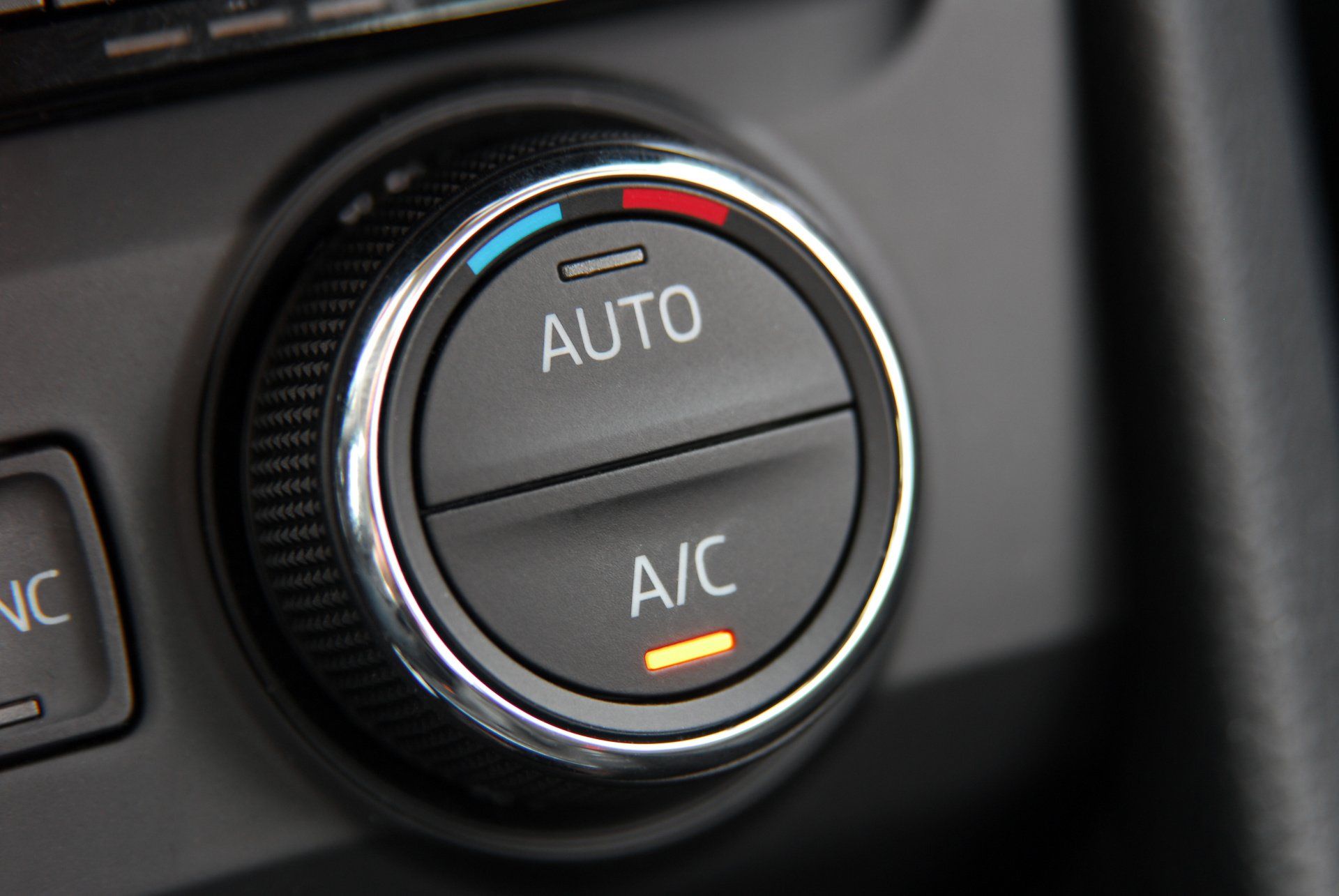 A close up of an auto and a/c button on a car