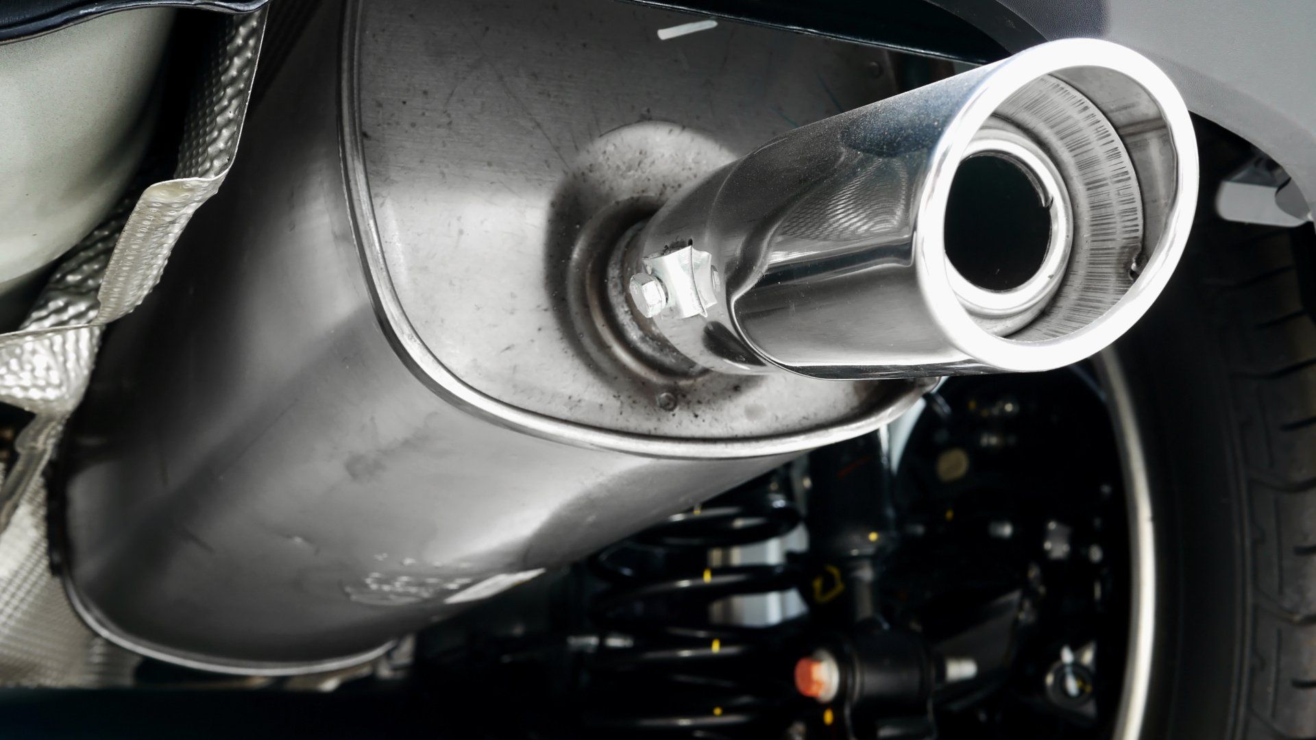 A close up of a car exhaust pipe on the back of a car.
