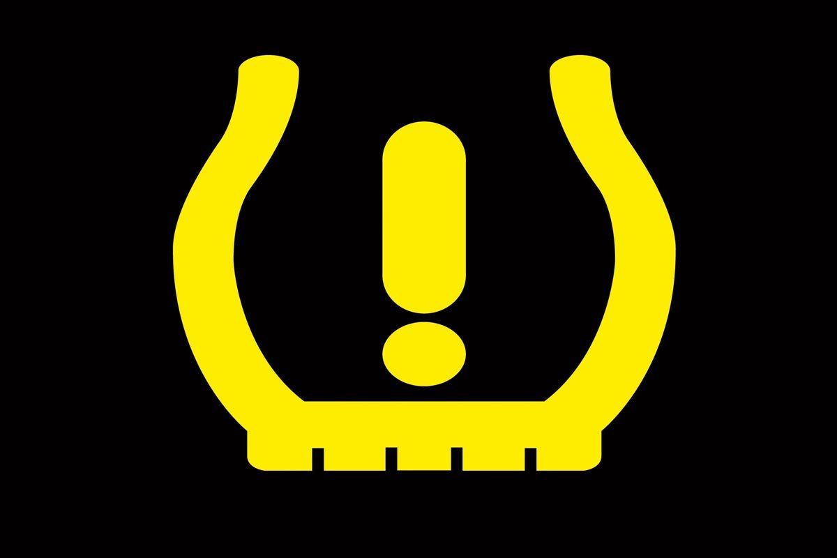 A yellow tire warning sign with an exclamation point on a black background.