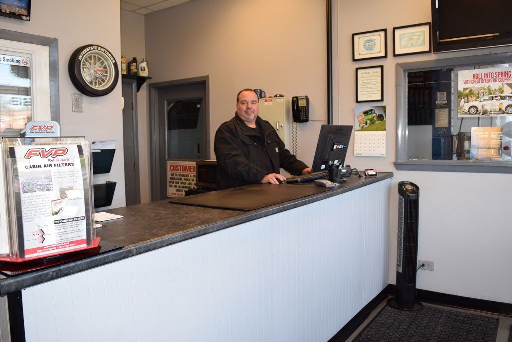 A man is sitting at a counter in front of a computer.
