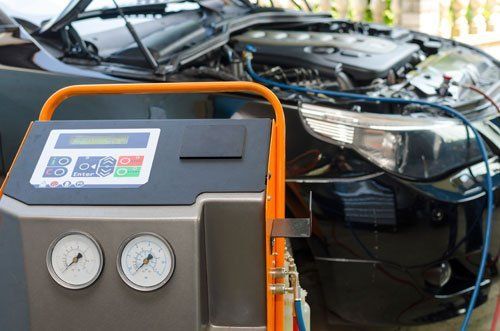 A car is being serviced with a machine in front of it.