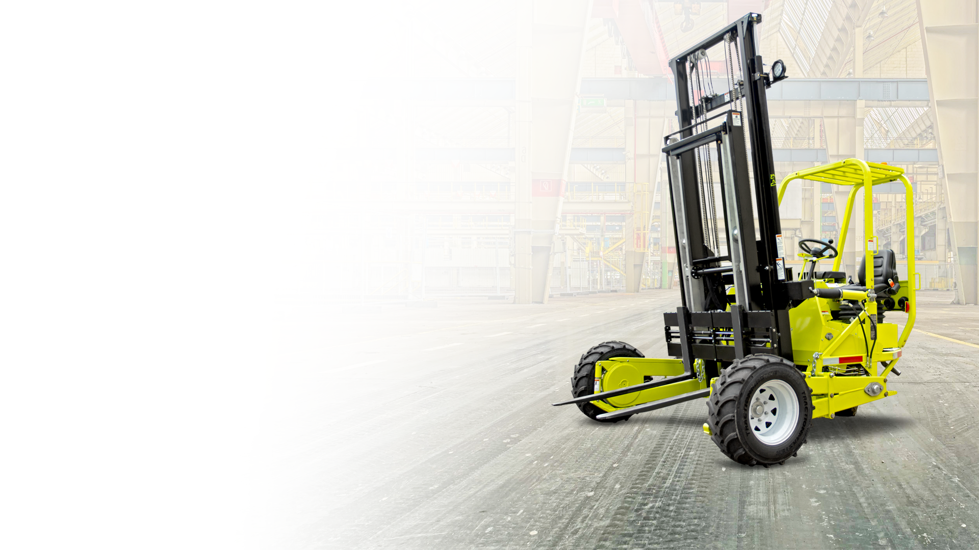 Yellow Clark forklift on a paved surface, with an interior background of crates.