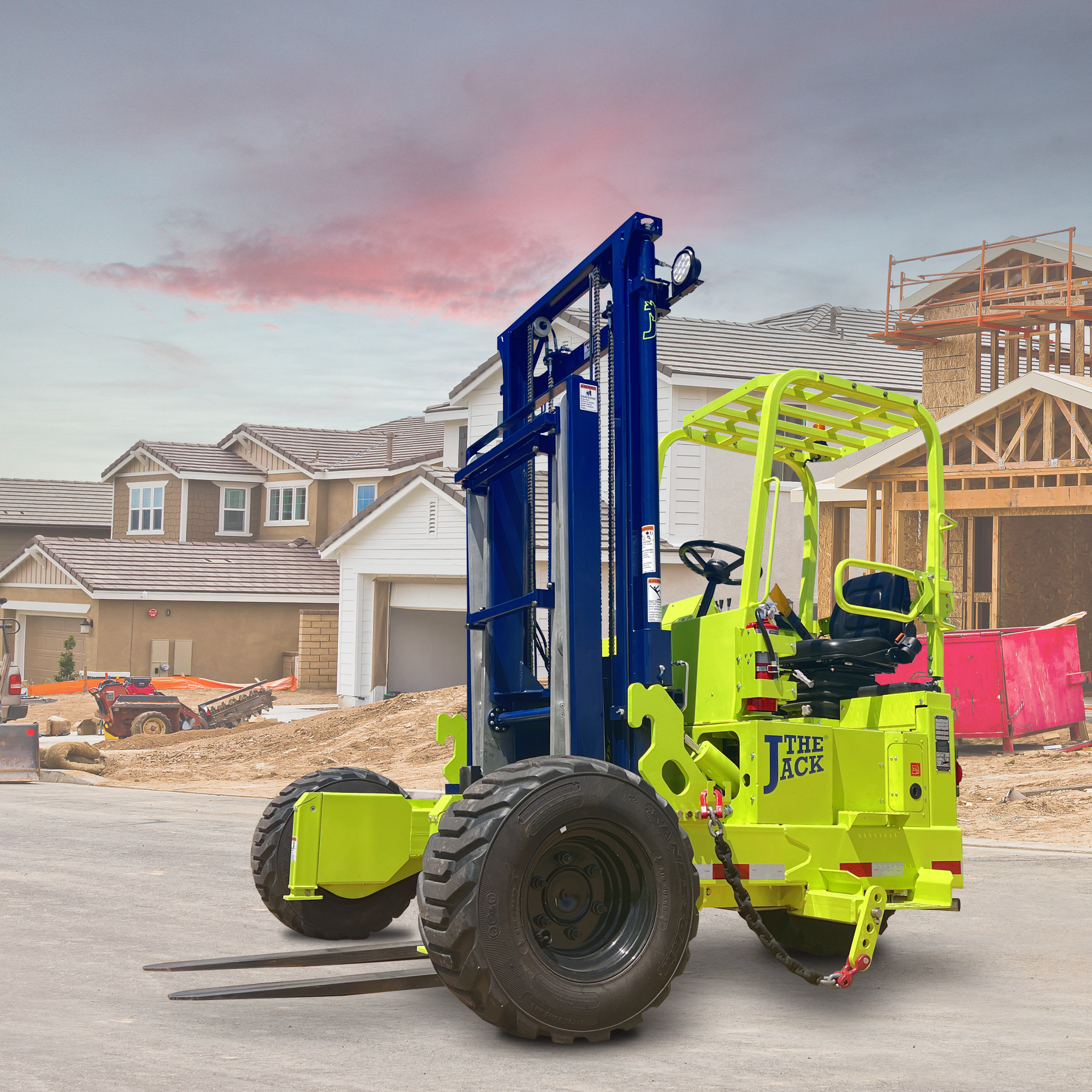 Lime-green forklift on a construction site with houses in the background under a cloudy sky.