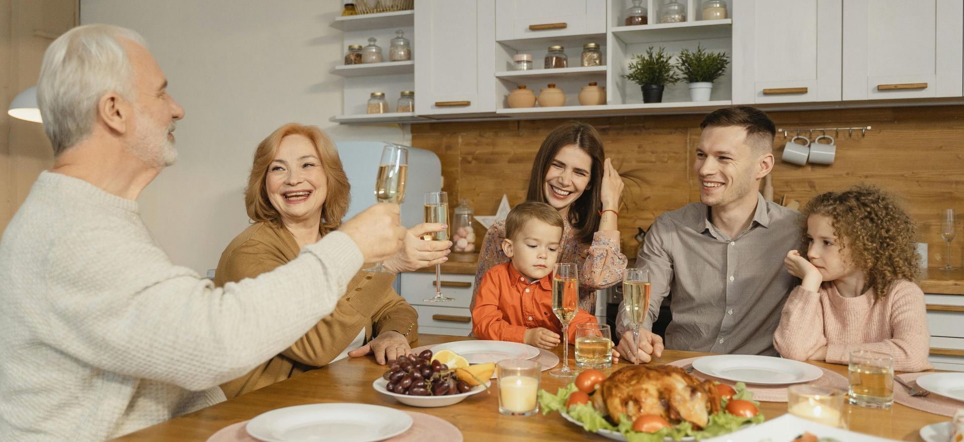 family around a dinner table toasting