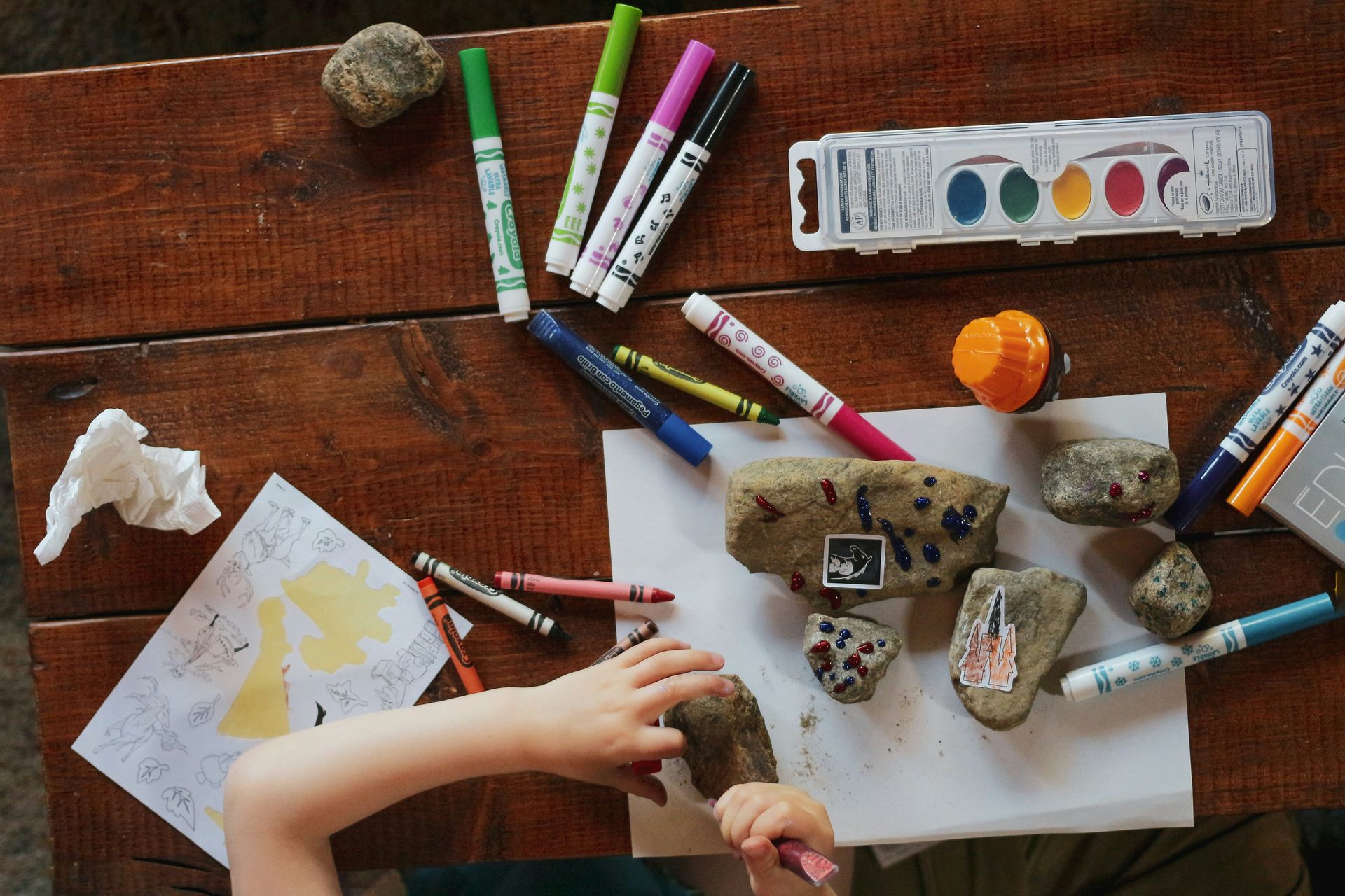 Children coloring with markers and art supplies.