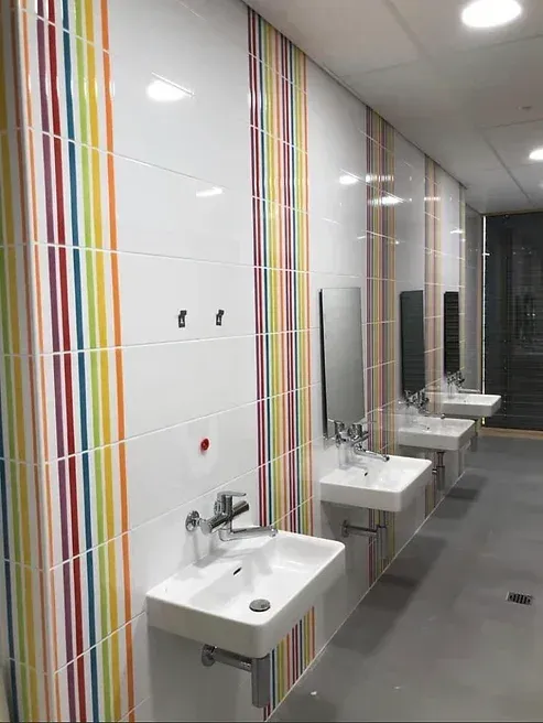 Une salle de bain avec une rangée de lavabos et de miroirs