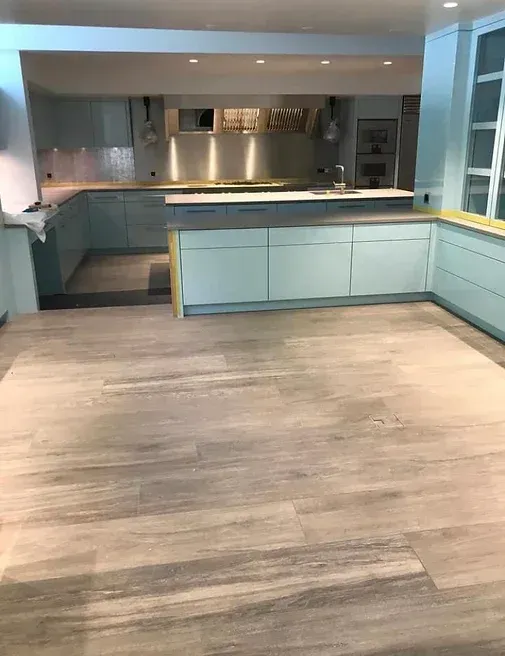 Une cuisine avec un plancher en bois et des appareils en acier inoxydable.