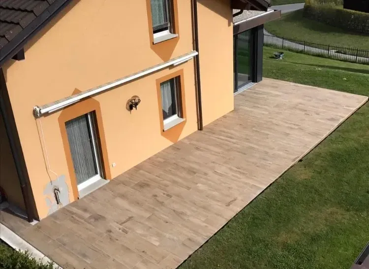 Une maison avec une terrasse en bois devant