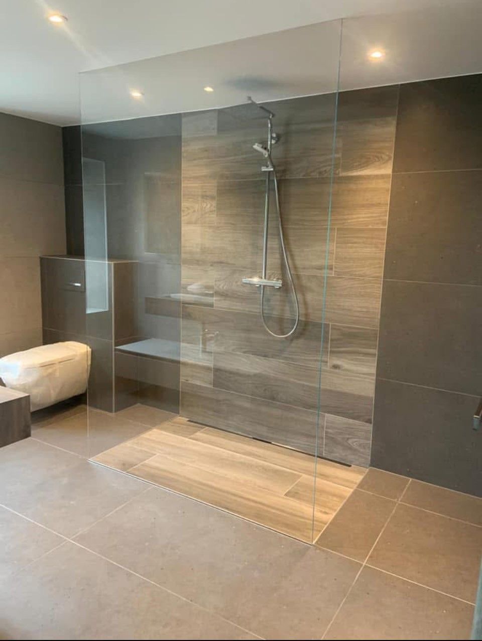 Une salle de bain avec douche à l'italienne et baignoire.