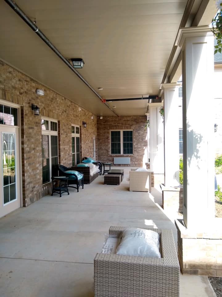 A large porch with a lot of furniture on it