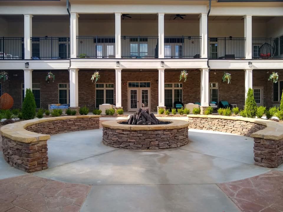 A large building with a fire pit in front of it.