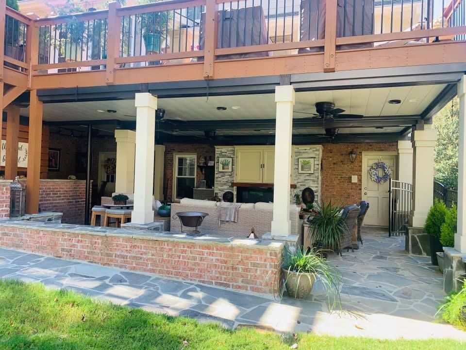 A patio with a wooden deck and a brick wall