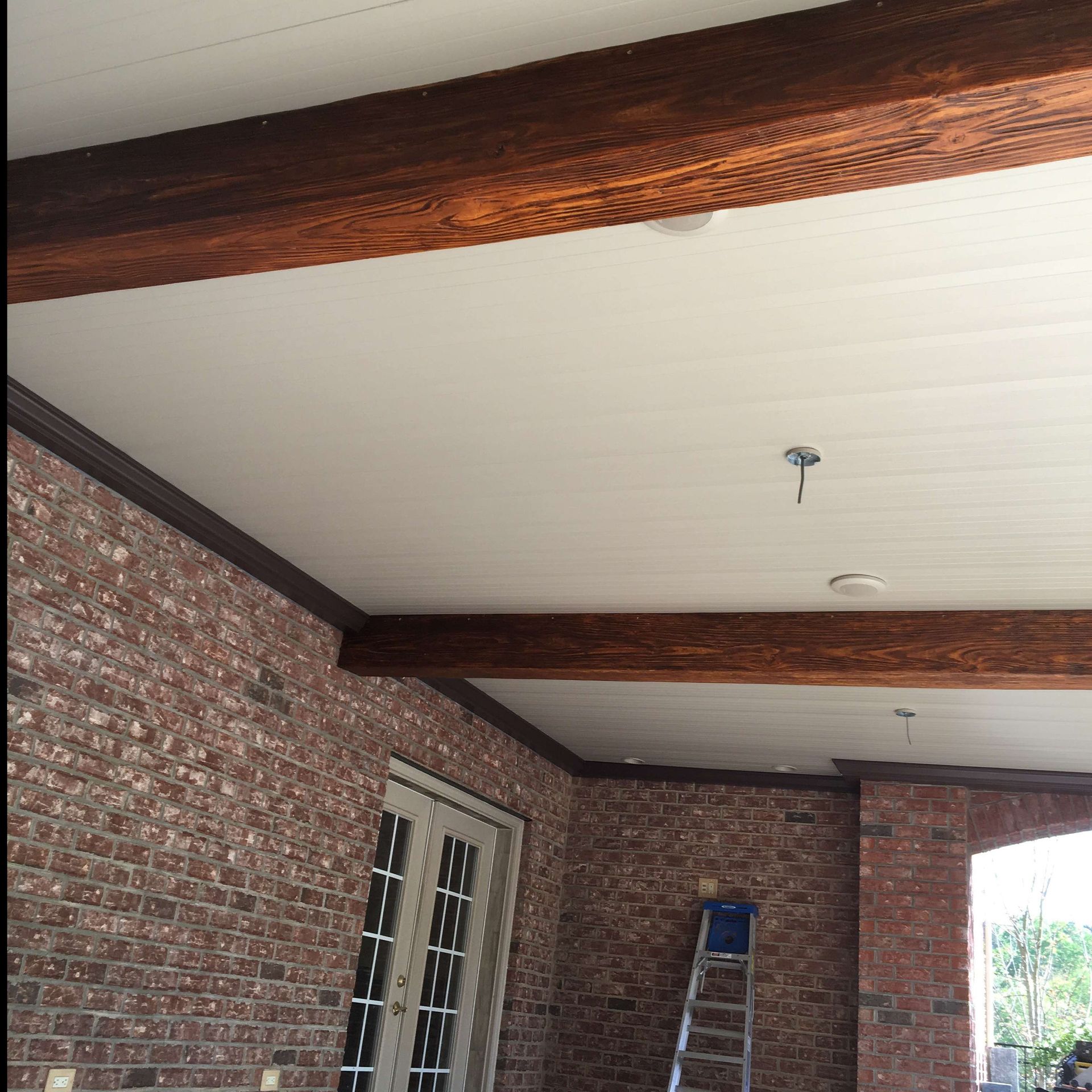 A brick building with a white ceiling and wooden beams