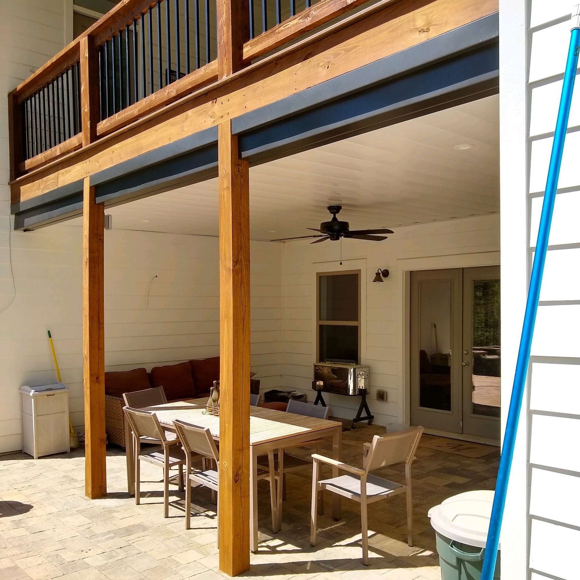 A patio with a table and chairs and a ceiling fan