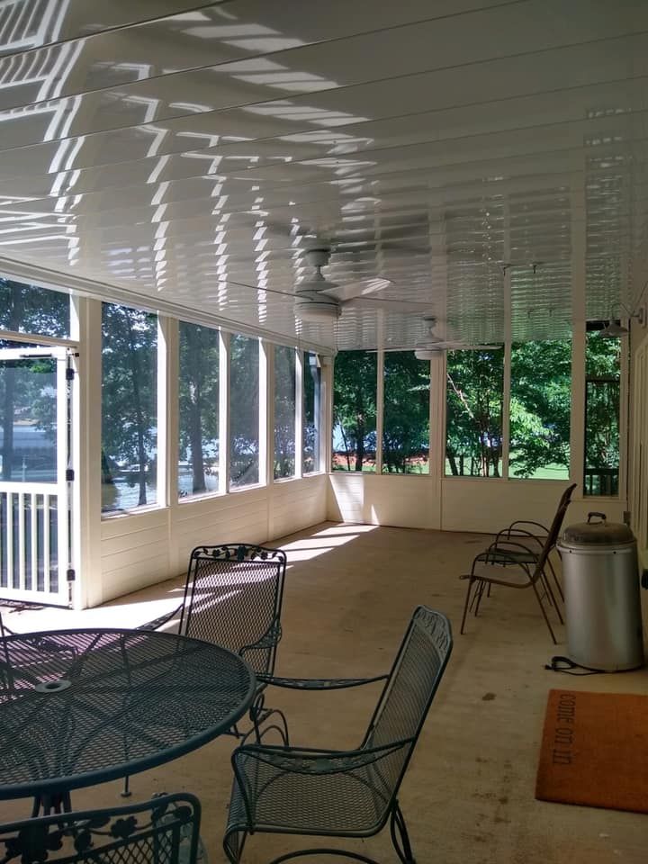 A screened in porch with a table and chairs