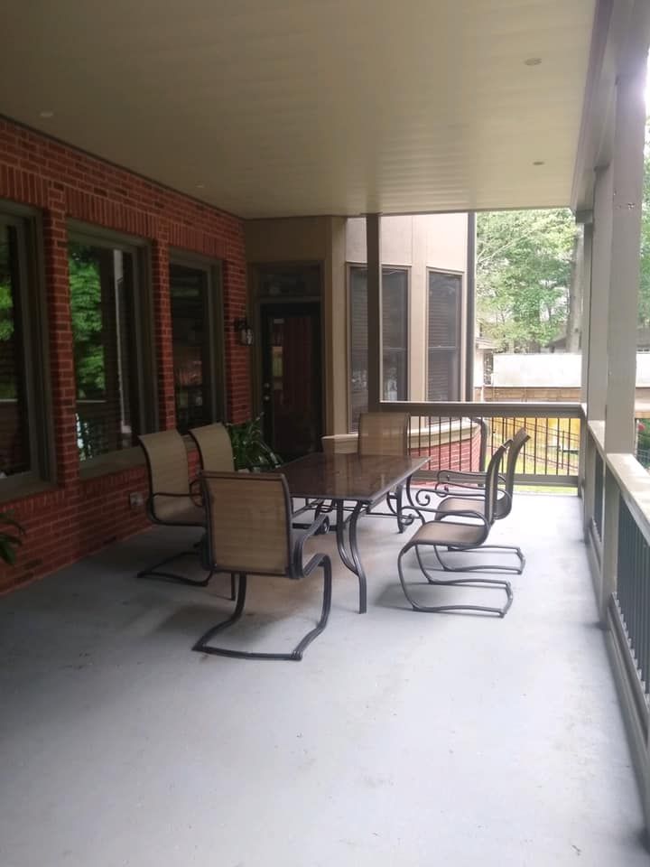 A screened in porch with a table and chairs.