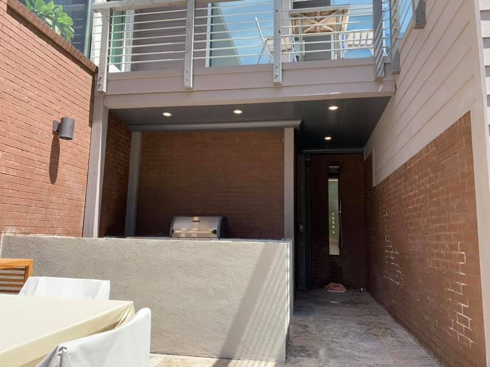 A brick building with a balcony and a grill