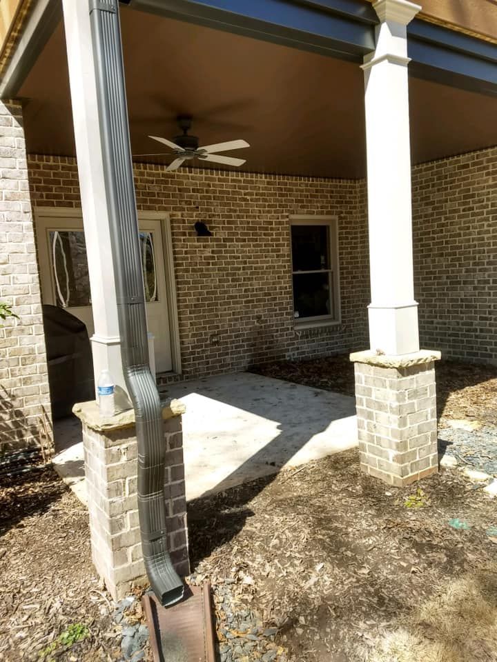 A brick house with a porch and a ceiling fan.