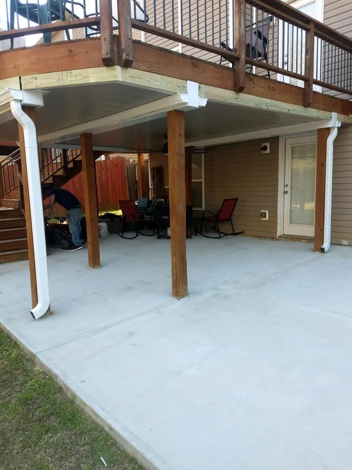 A wooden deck with a concrete patio underneath it