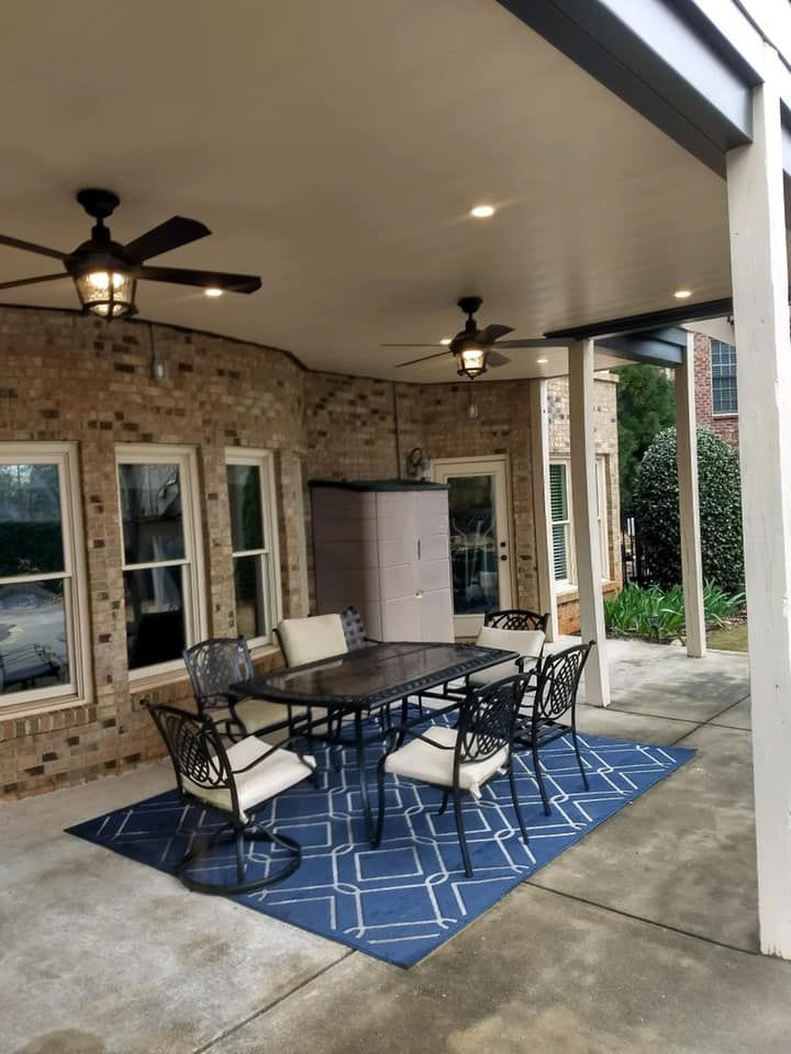 A patio with a table and chairs under a ceiling fan.
