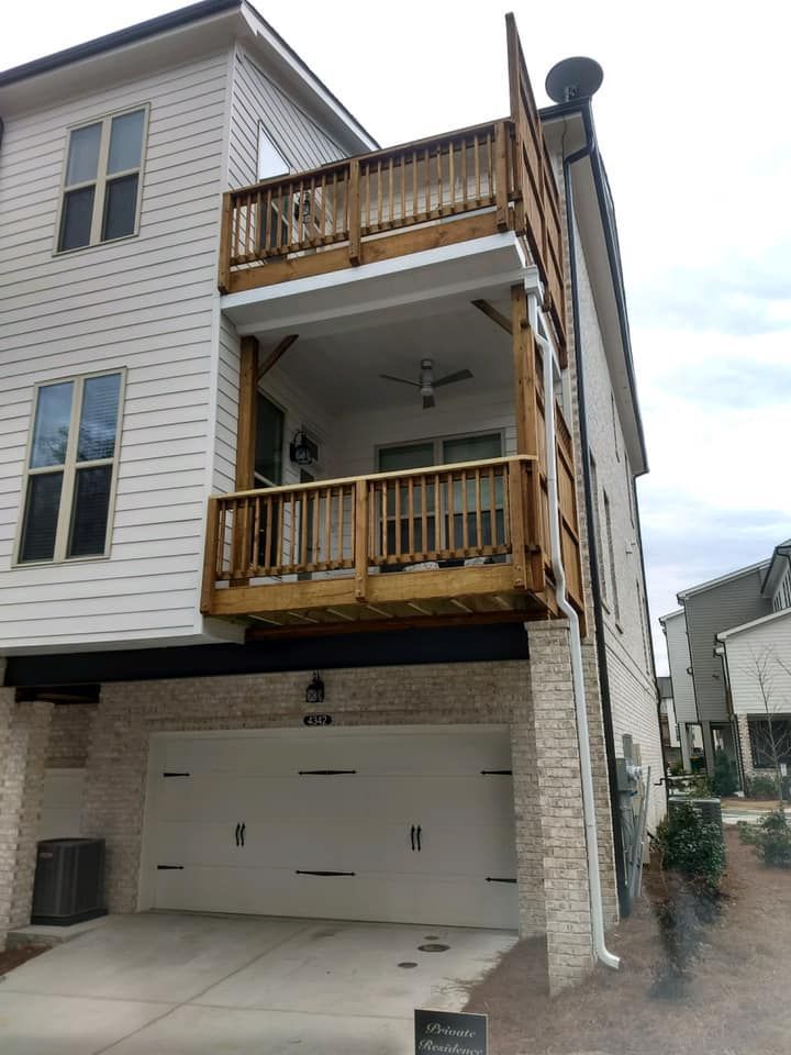 A white house with a balcony and a garage