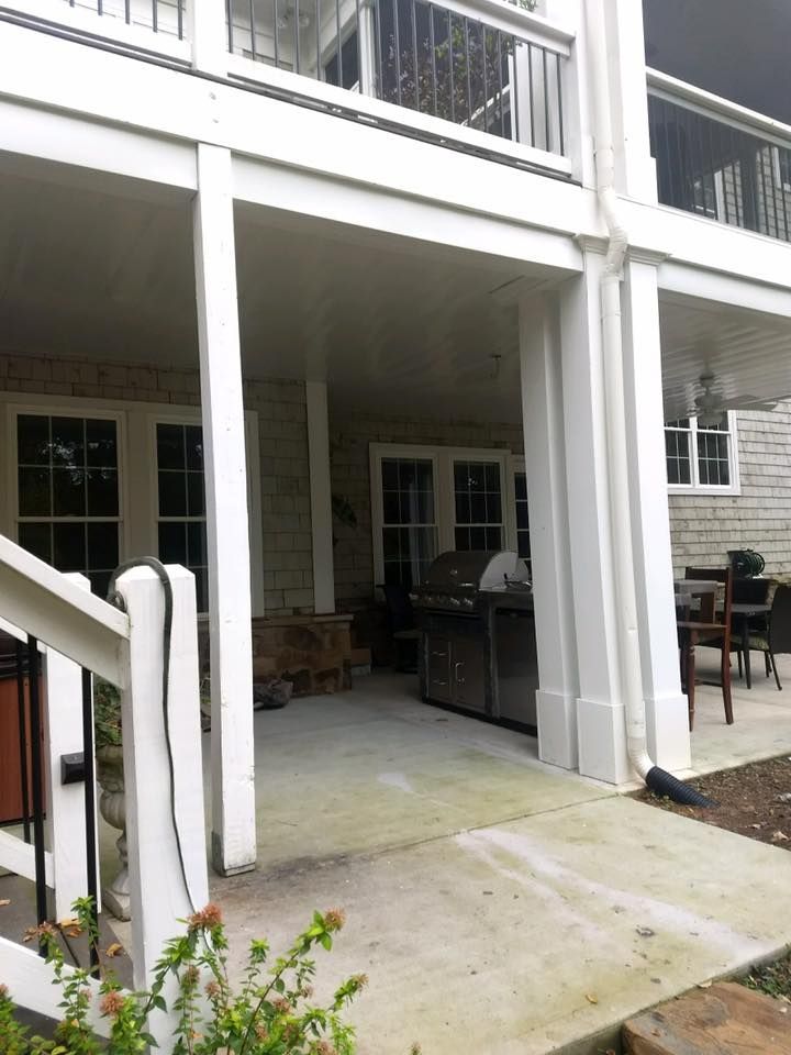 A large white house with a covered porch and stairs leading up to it.