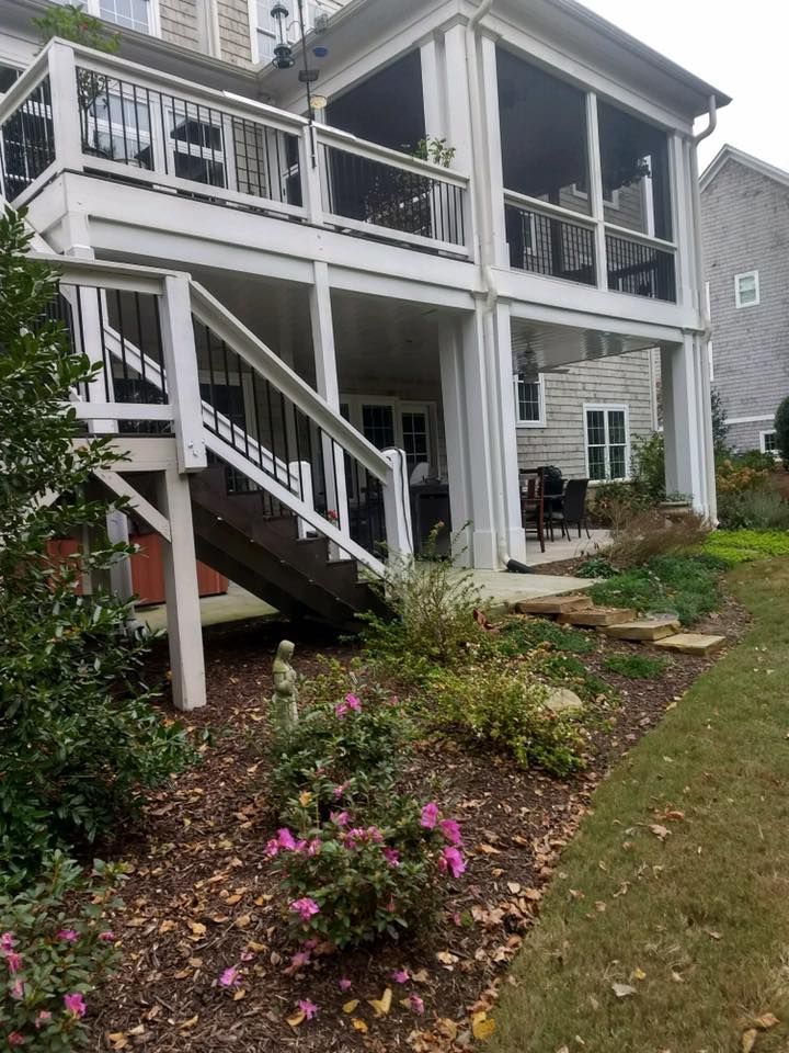 A house with a screened in porch and stairs leading up to it.