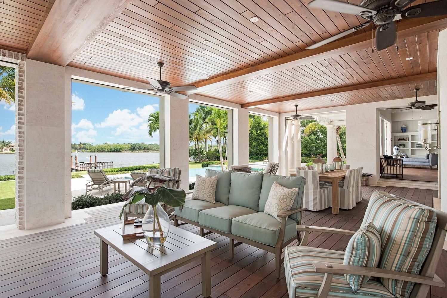 A living room with a couch , chairs , table and ceiling fan.