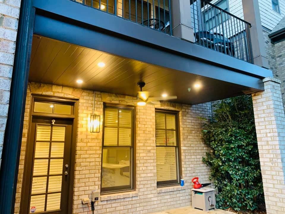 A brick house with a balcony and a porch.