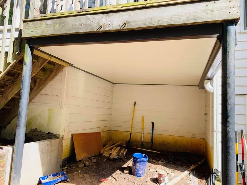 A garage with a bucket of sand and shovels in it.