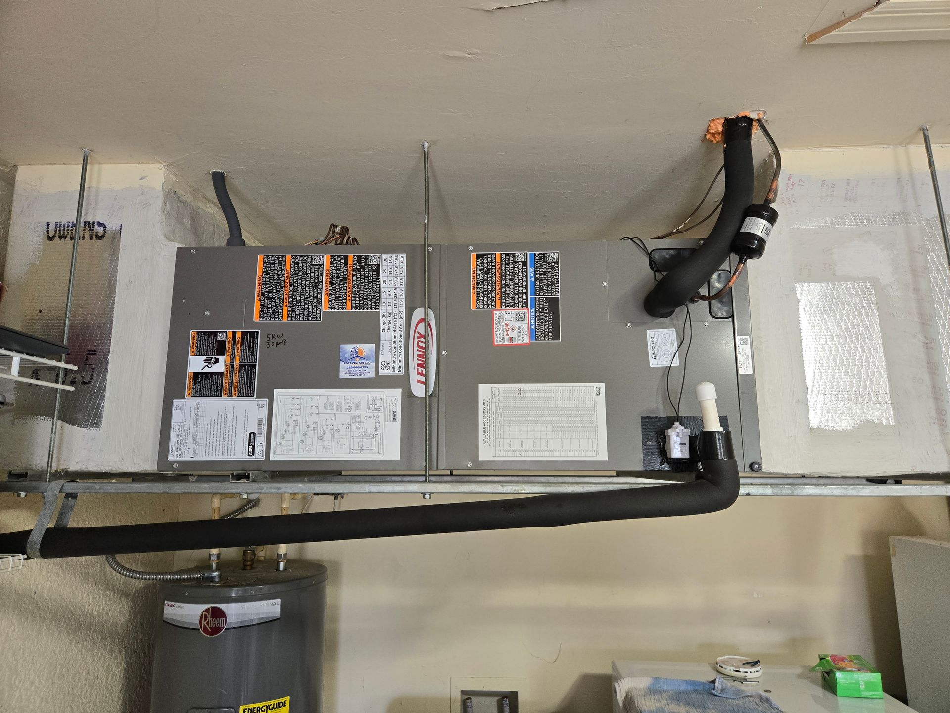 HVAC system installed in a garage; includes two units with ductwork and a water heater nearby.