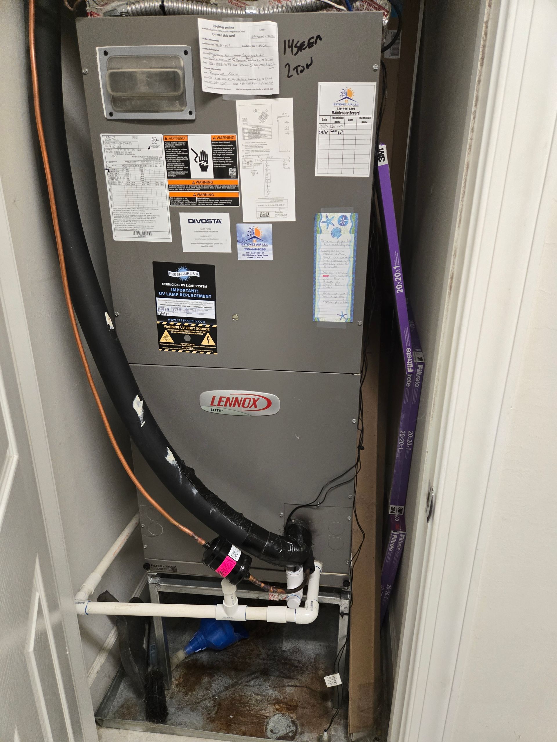 HVAC unit suspended from ceiling in a garage. Ductwork, filter, and water heater are visible.
