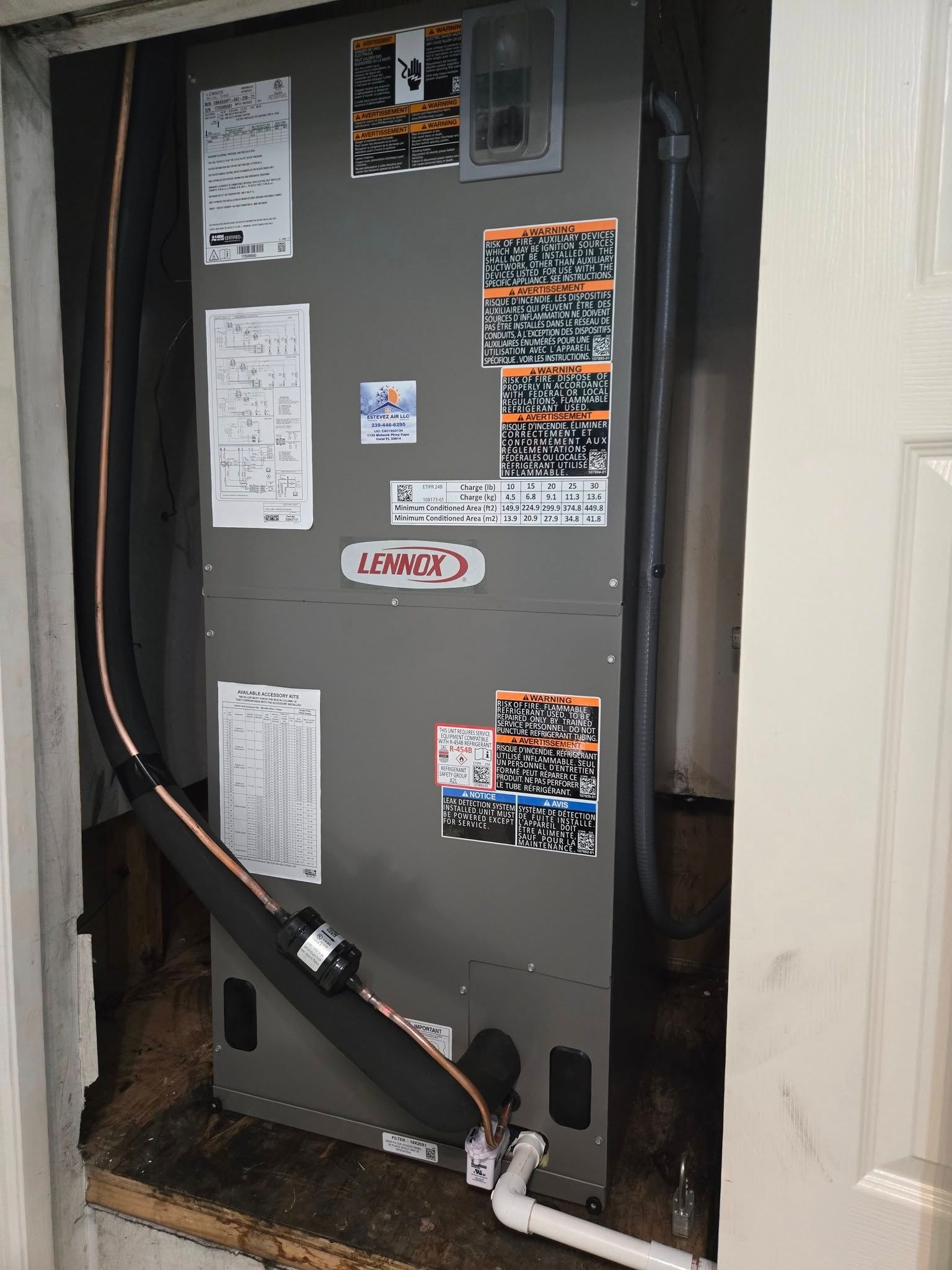 A gray Lennox HVAC unit, installed in a narrow opening with insulated pipes.