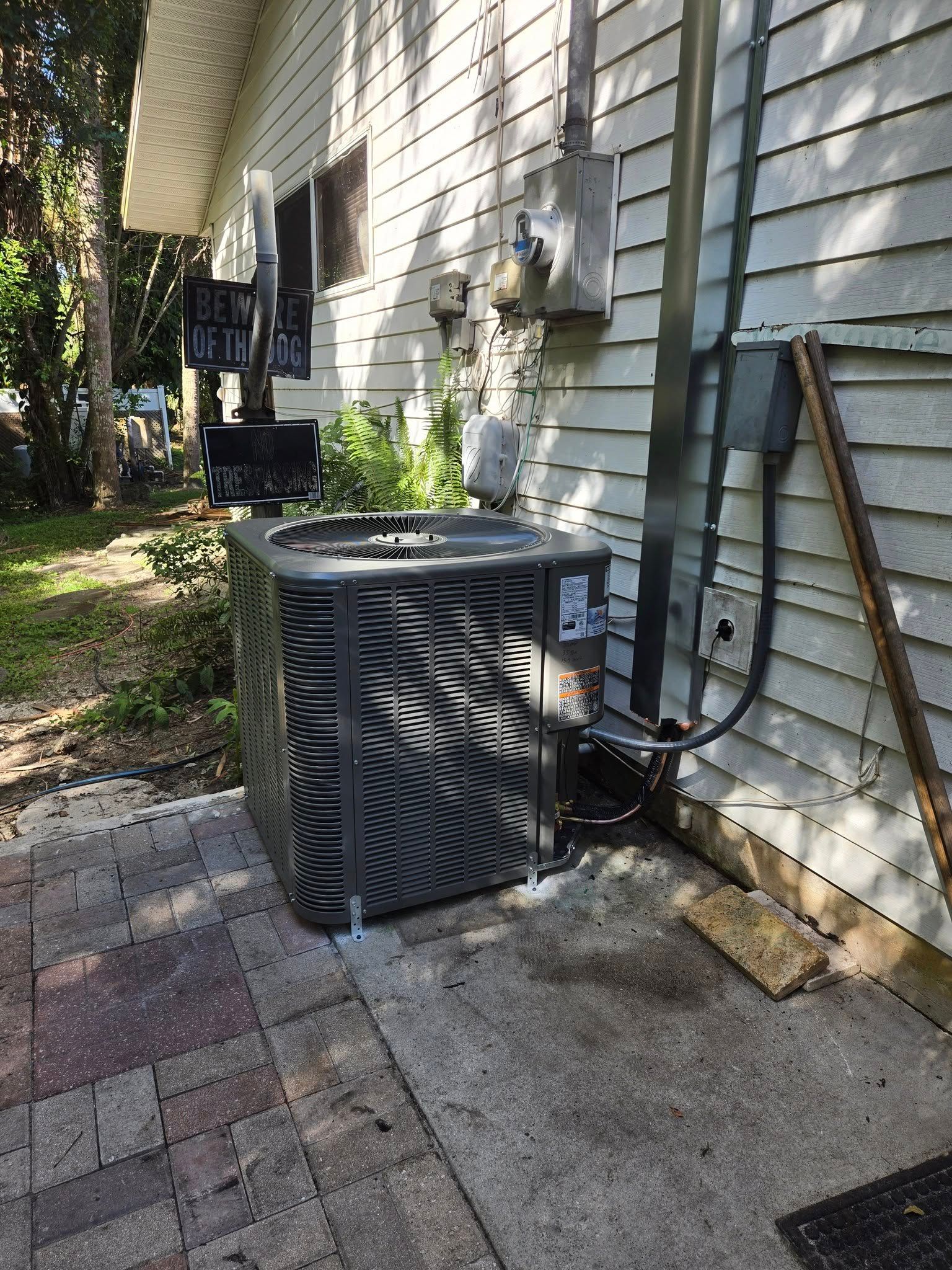 HVAC unit outside a home, next to electrical box and gas meter.