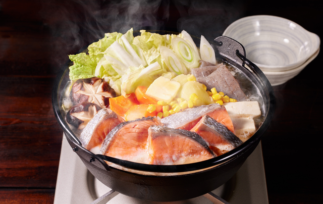 A pot of food is cooking on a stove.