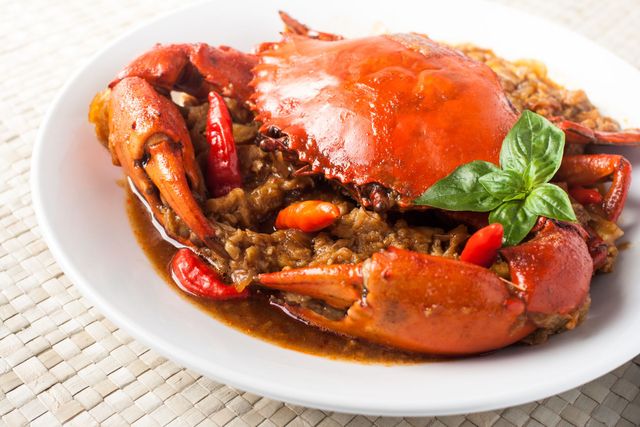 A close up of a plate of crab with sauce on a table.