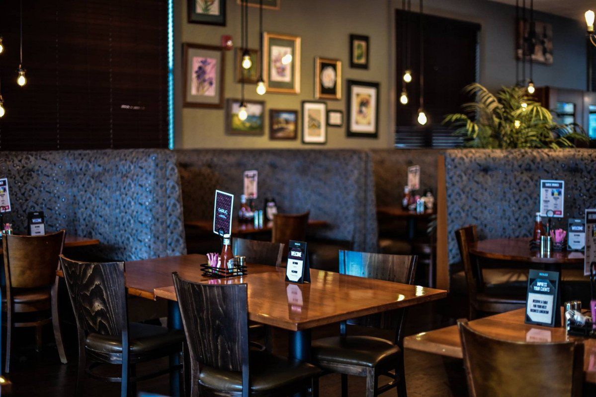 A restaurant with tables and chairs and pictures on the wall.