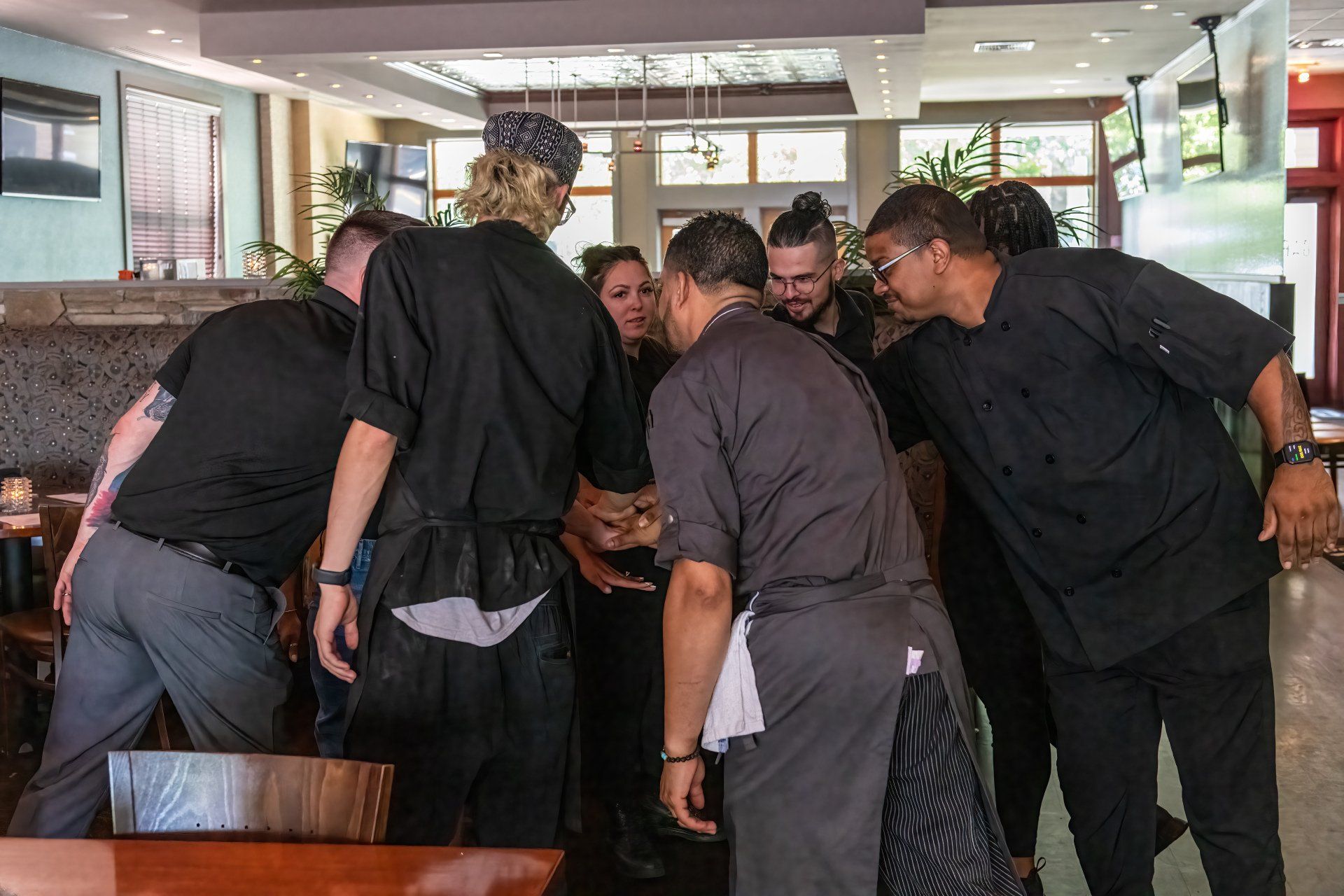 A group of people are huddled together in a restaurant.