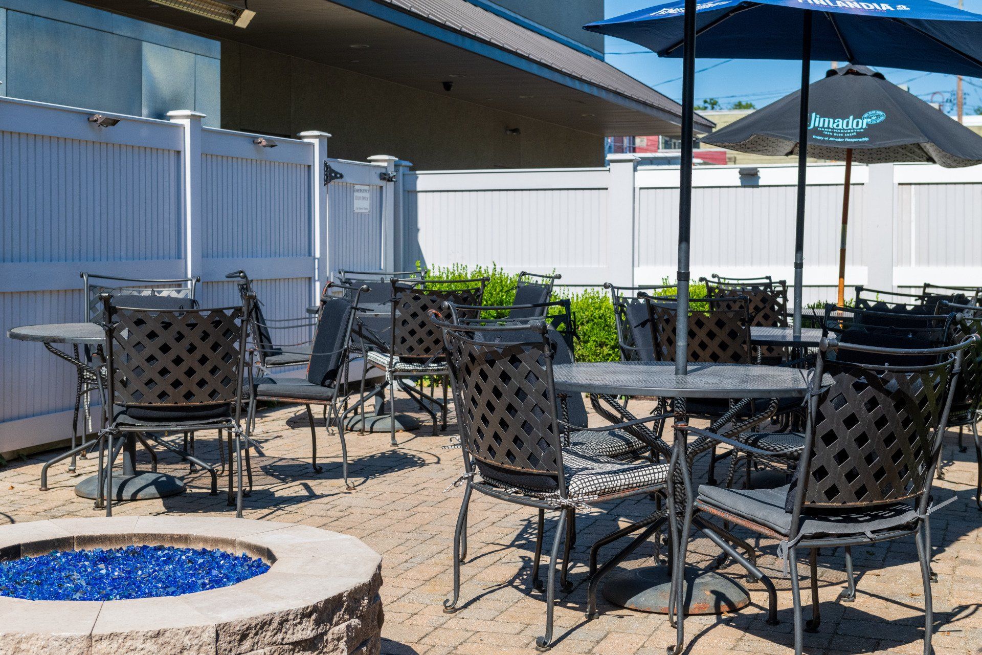 A patio with tables and chairs and a fire pit