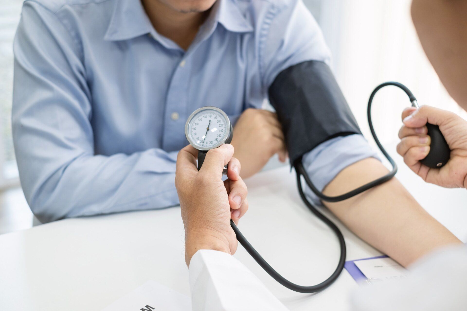 doctor using blood pressure cuff on male patient