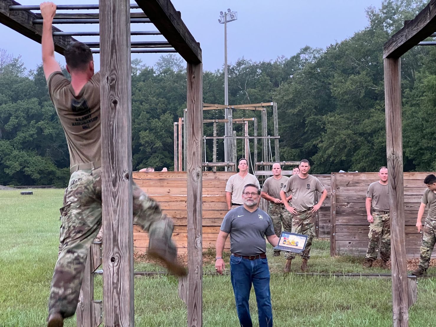 A man in a military uniform is climbing a wooden ladder.