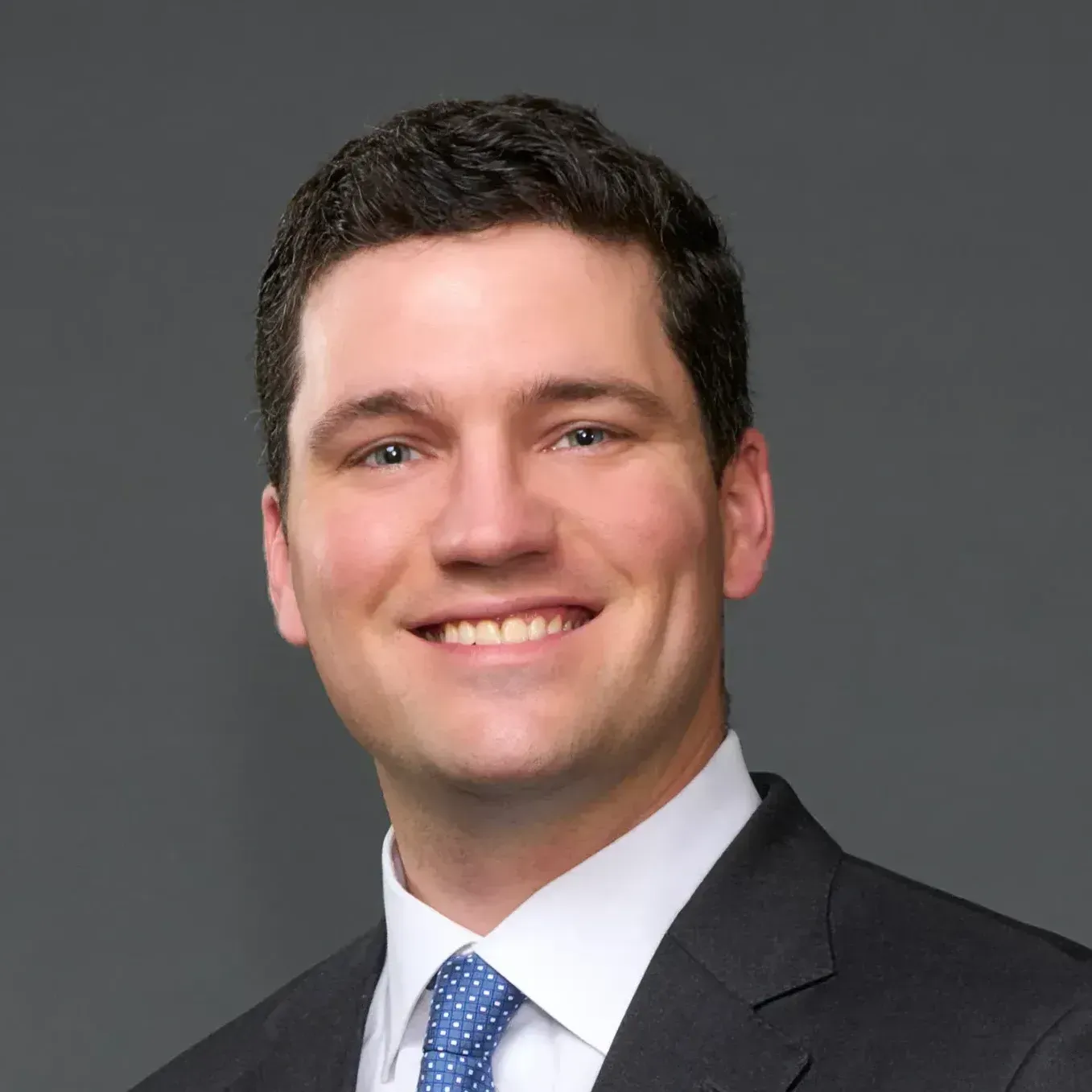 A man in a suit and tie is smiling for the camera.